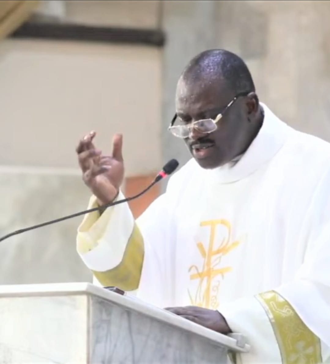 Padre Mike preaching from the ambo in white vestments