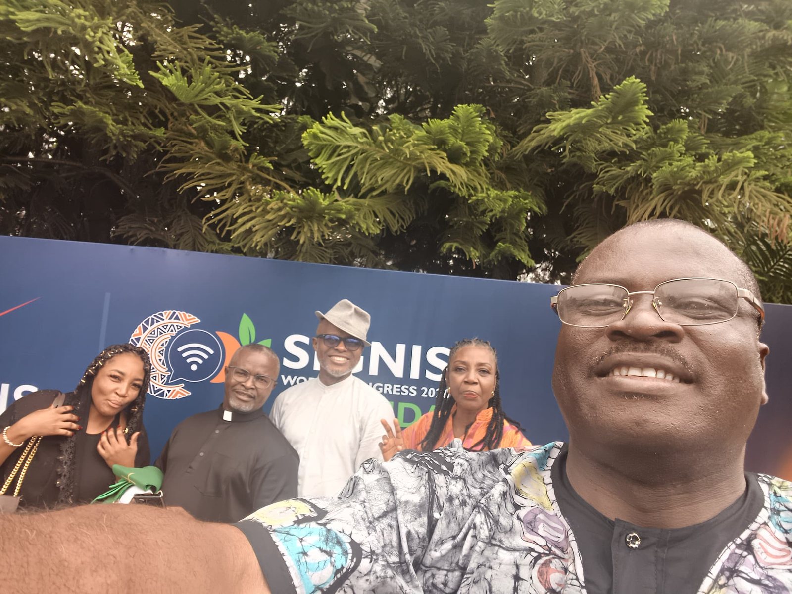 Padre Mike with delegates in front of the SIGNIS World Congress banner